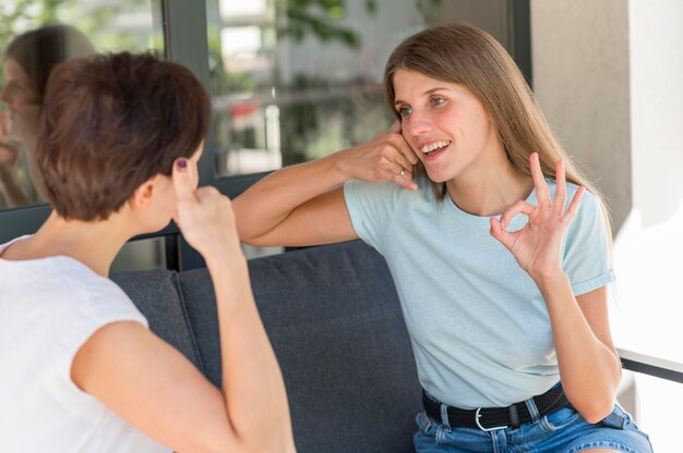 Mujeres que usan el lenguaje de señas para conversar entre sí