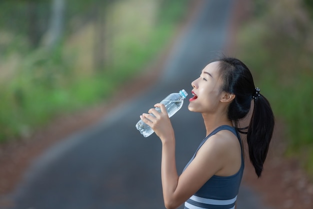 Las mujeres que usan ropa deportiva beben agua después de correr
