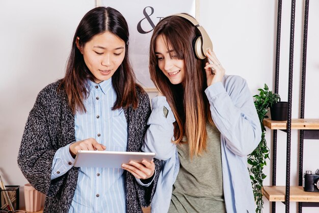 Mujeres que usan tabletas y escuchando música