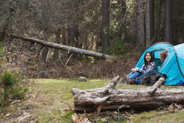 Mujeres relajadas acampando en el bosque