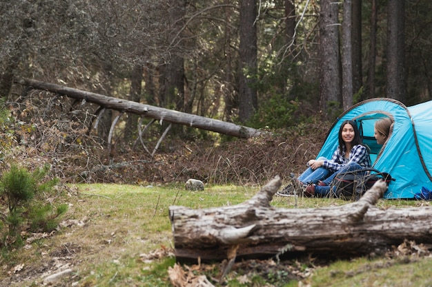 Mujeres relajadas acampando en el bosque