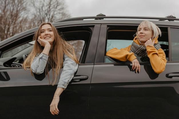 Mujeres relajantes fuera de la ventana del coche