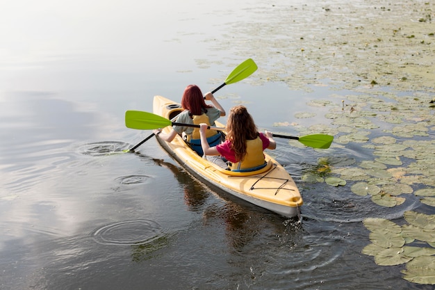 Foto gratuita mujeres remando en kayak en el lago