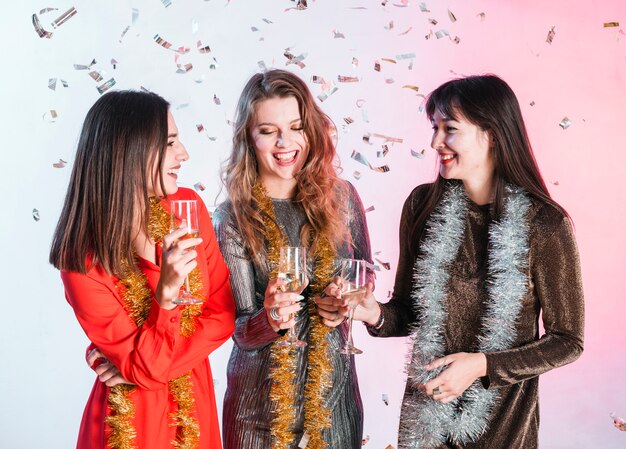 Mujeres riendo bebiendo champán en la fiesta de Navidad