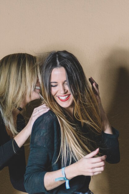 Mujeres riendo cerca de la pared