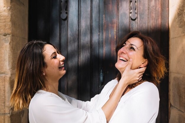 Mujeres riendo cerca de la puerta de madera