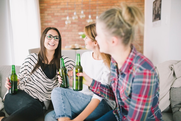 Mujeres riendo relajarse con cerveza en casa