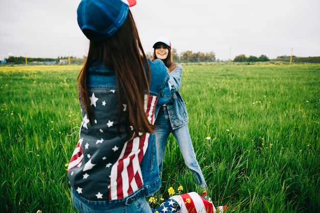 Mujeres en ropa jeans jugando en el campo