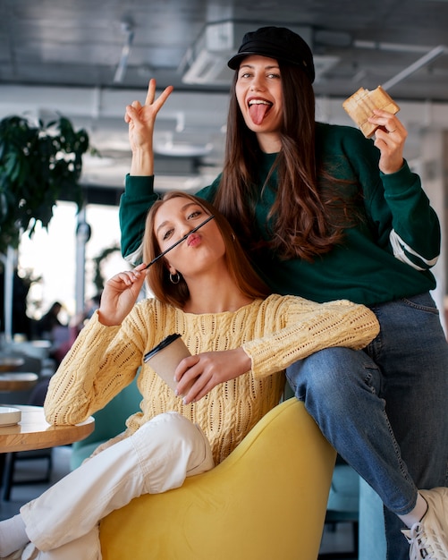 Foto gratuita mujeres con sándwiches envueltos en papel