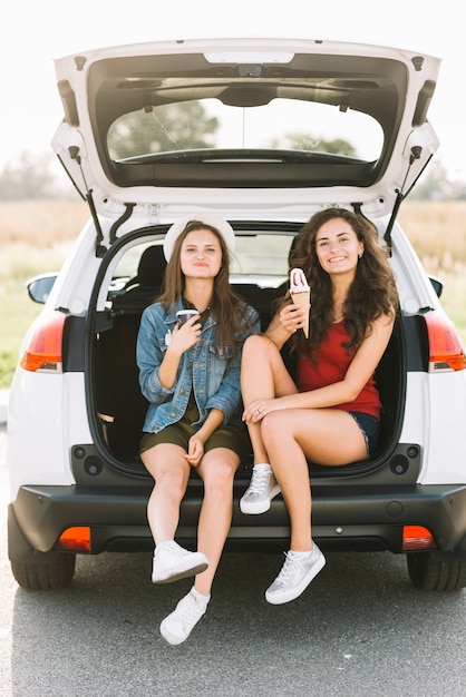 Mujeres sentadas en el coche con helado