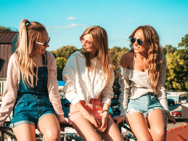 Mujeres sexy sentadas en pasamanos en la calle Se comunican y discuten algo