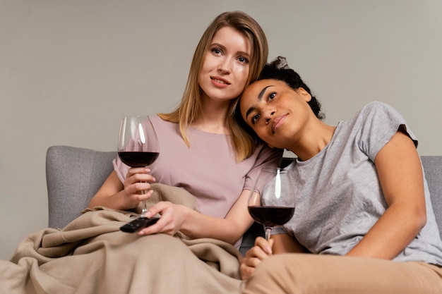 Mujeres en el sofá viendo la televisión y bebiendo vino