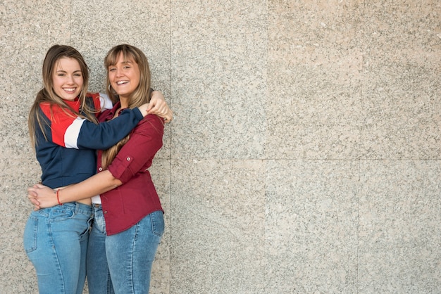 Mujeres sonrientes abrazándose unos a otros con espacio de copia