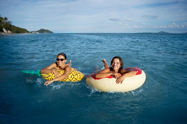 Foto gratuita mujeres sonrientes de alto ángulo en flotadores