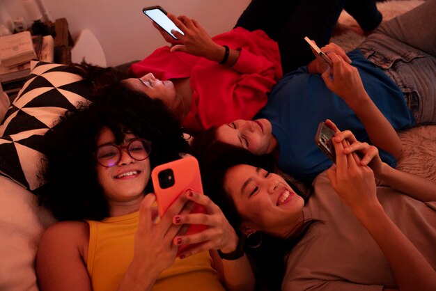 Mujeres sonrientes de alto ángulo con teléfonos inteligentes