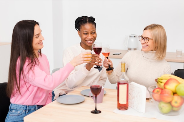 Mujeres sonrientes animando con una copa de vino