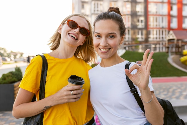 Mujeres sonrientes en la ciudad usando lenguaje de señas