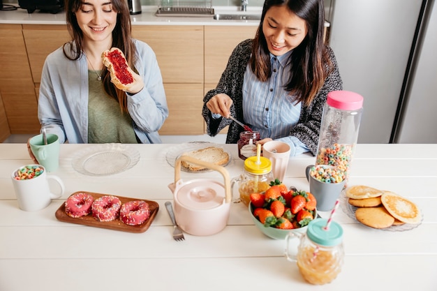 Mujeres sonrientes desayunando bien