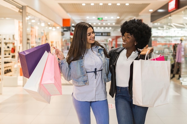 Mujeres sonrientes felices juntos de compras