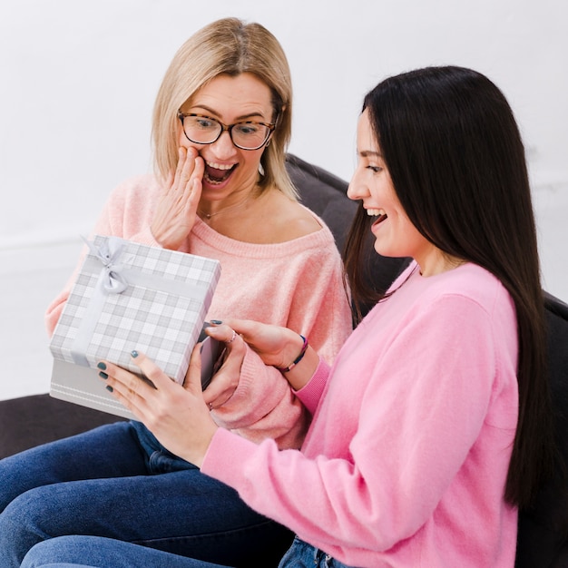 Foto gratuita mujeres sonrientes intercambiando regalos