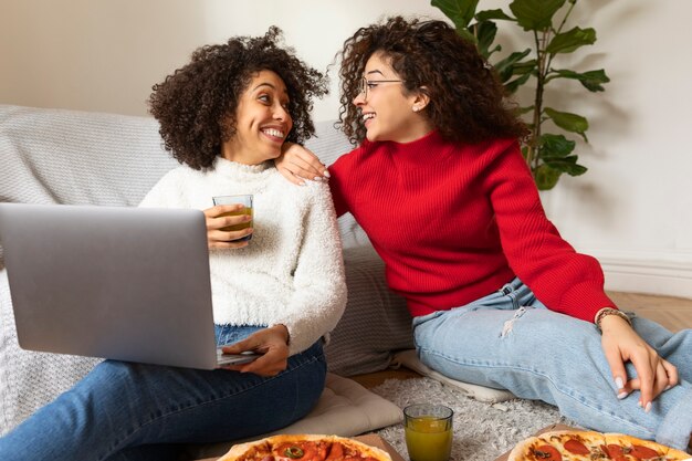 Mujeres sonrientes con laptop de tiro medio