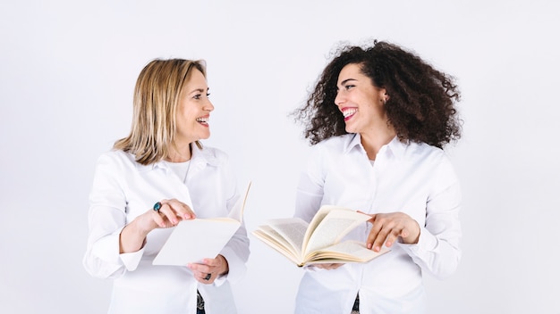 Mujeres sonrientes leyendo libros