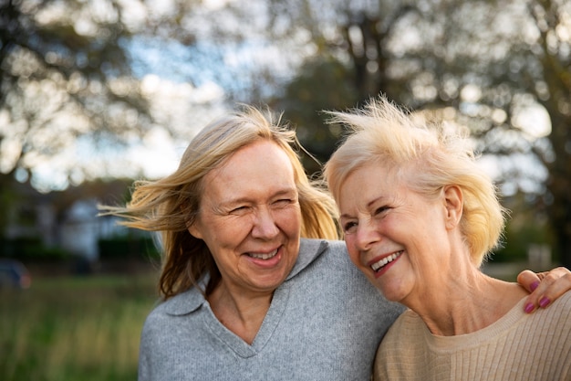 Foto gratuita mujeres sonrientes en la naturaleza tiro medio