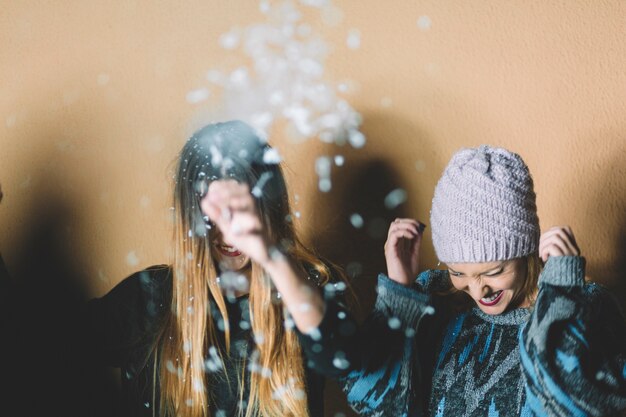 Mujeres sonrientes bajo la nieve