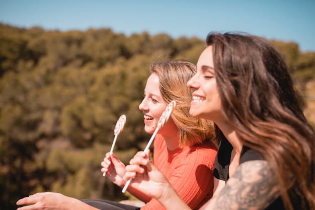 Foto gratuita mujeres sonrientes con piruletas