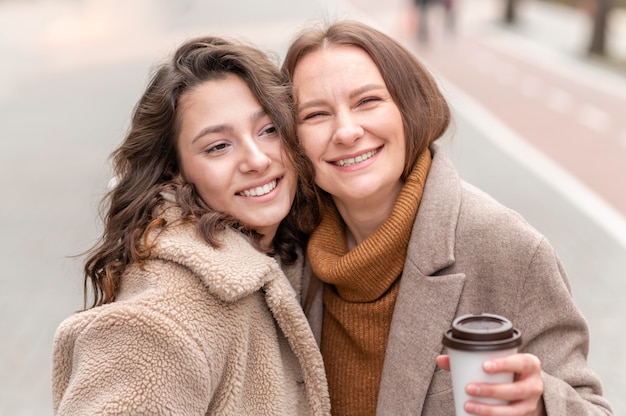 Foto gratuita mujeres sonrientes posando juntos al aire libre