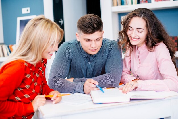 Mujeres sonrientes que estudian con el hombre