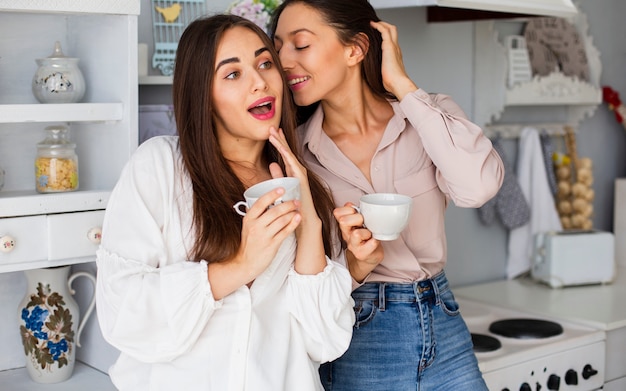 Mujeres sonrientes que tienen descanso para tomar café