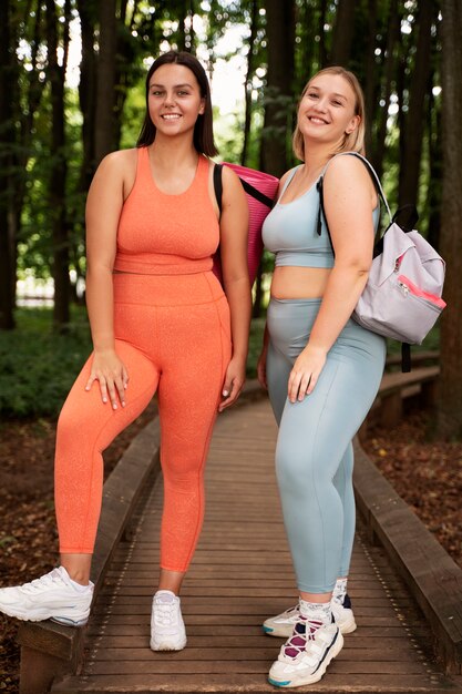 Mujeres sonrientes de tiro completo afuera