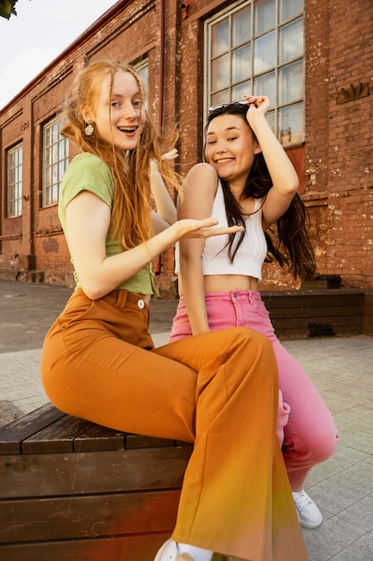 Foto gratuita mujeres sonrientes de tiro completo divirtiéndose