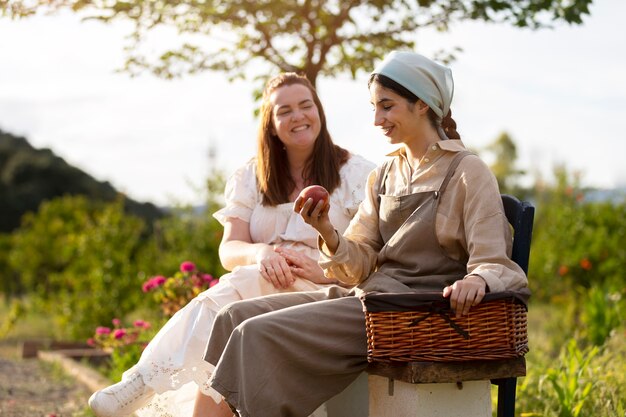 Mujeres sonrientes de tiro completo con frutas