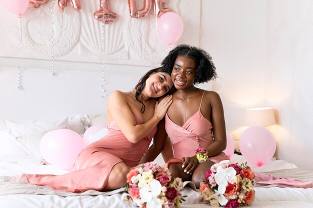 Mujeres sonrientes de tiro completo con ramo de flores