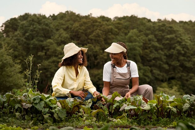 Mujeres sonrientes de tiro completo con sombreros