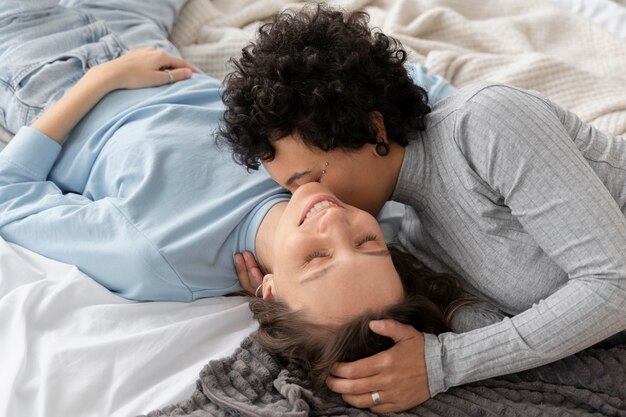 Mujeres sonrientes de tiro medio en la cama