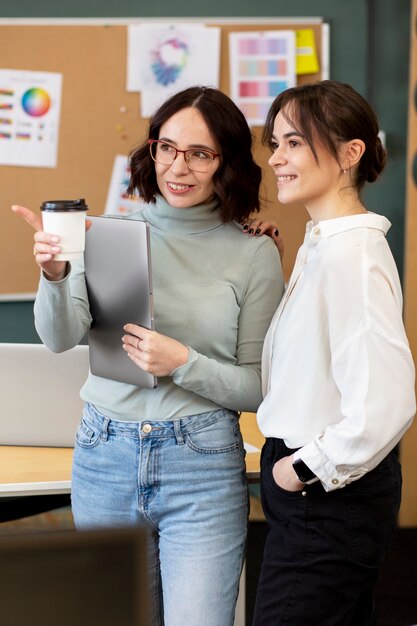 Mujeres sonrientes de tiro medio chateando