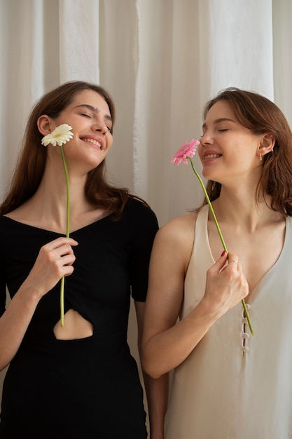 Mujeres sonrientes de tiro medio con flores.