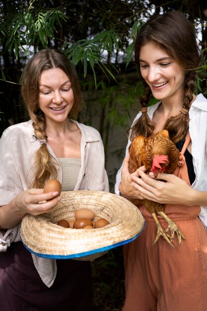 Mujeres sonrientes de tiro medio con huevos