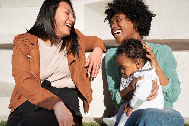 Mujeres sonrientes de tiro medio con lindo bebé