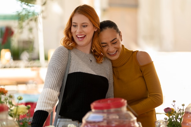 Mujeres sonrientes de tiro medio en el mercado de pulgas