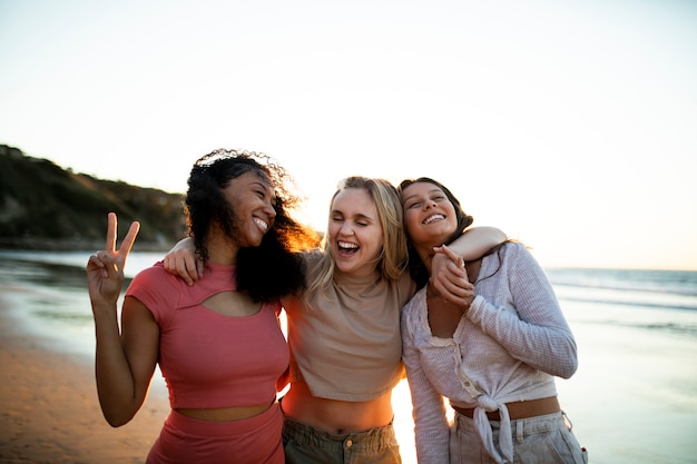 Mujeres sonrientes de tiro medio en la playa