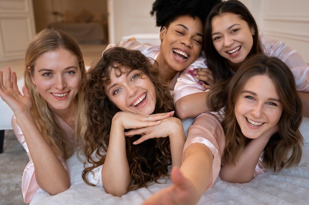 Mujeres sonrientes de tiro medio posando juntas