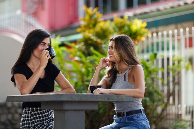 Mujeres sonrientes de tiro medio que pasan tiempo al aire libre