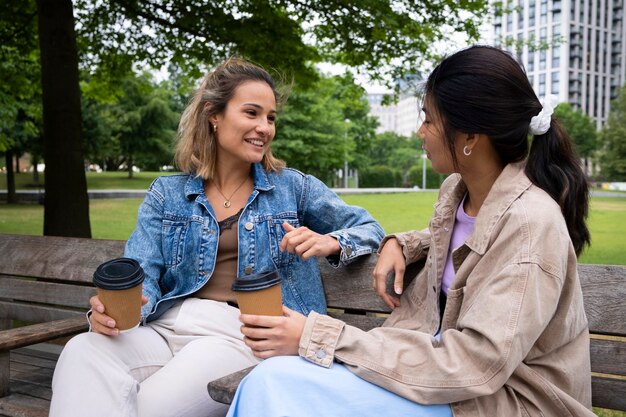 Mujeres sonrientes de tiro medio con tazas de café