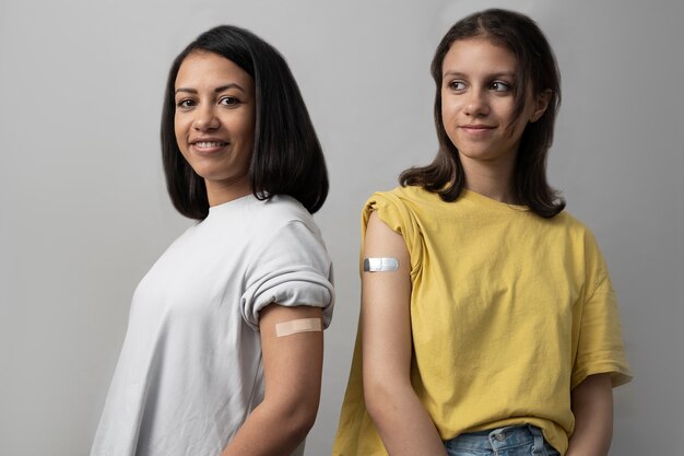 Mujeres sonrientes de tiro medio con tiritas