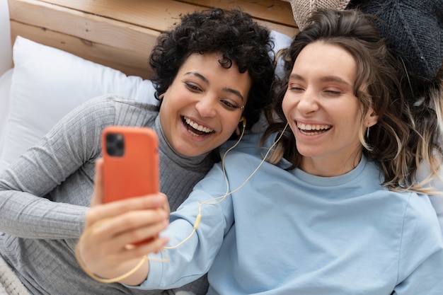 Foto gratuita mujeres sonrientes de tiro medio tomando selfie