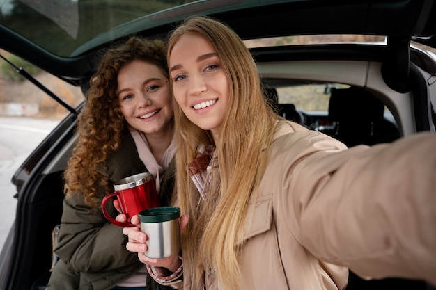 Mujeres sonrientes de tiro medio tomando selfie